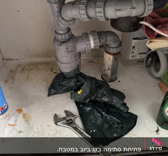 כלי עבודה וצנרת מתחת לכיור מטבח